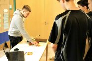 Junge Männer an Tisch mit Geldscheinen