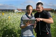 Landwirtin und Berater mit Laptop im Feld