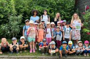 Kindergartenkinder mit Rucksack und Mützen und Erzieherinnen mit Urkunde