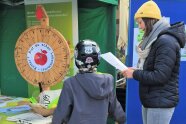 Kind und Frau stehen an Glücksrad